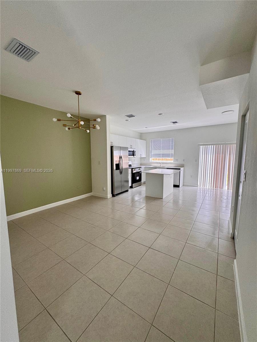 15538 Southwest 276th Terrace Homestead, FL 33032 - Photo 6 of 16 a view of empty room with wooden floor and fan