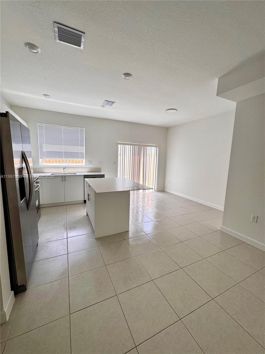 15538 Southwest 276th Terrace Homestead, FL 33032 - Photo 8 of 16 a kitchen with stainless steel appliances a sink a stove a microwave and cabinets