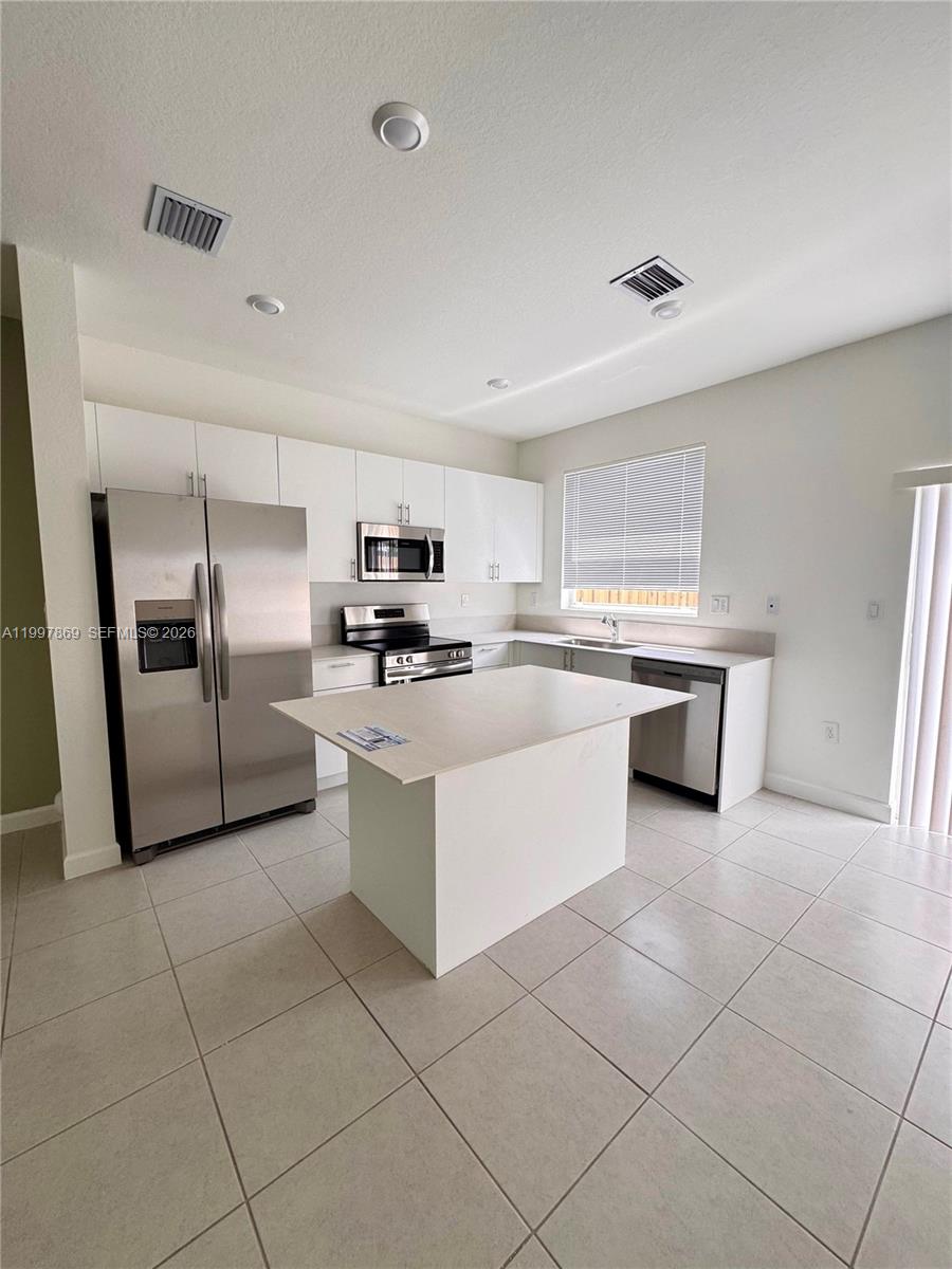 15538 Southwest 276th Terrace Homestead, FL 33032 - Photo 9 of 16 a kitchen with stainless steel appliances granite countertop a refrigerator and a stove top oven
