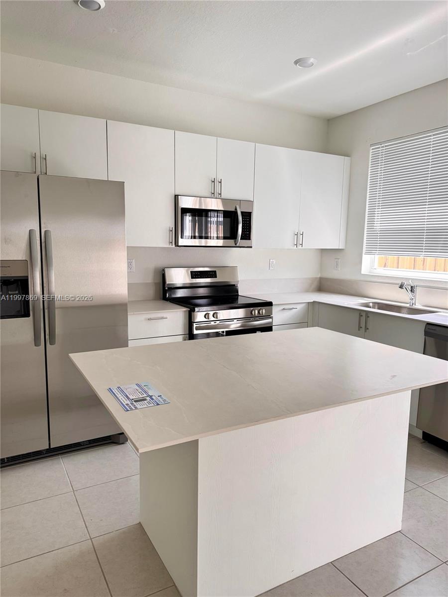 15538 Southwest 276th Terrace Homestead, FL 33032 - Photo 10 of 16 a kitchen with stainless steel appliances a refrigerator sink and stove