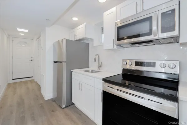 a kitchen with stainless steel appliances a stove a microwave and a refrigerator