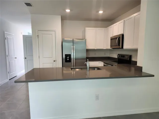 a kitchen with stainless steel appliances granite countertop a sink a stove and a refrigerator