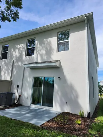 a view of a house with a big yard and large trees