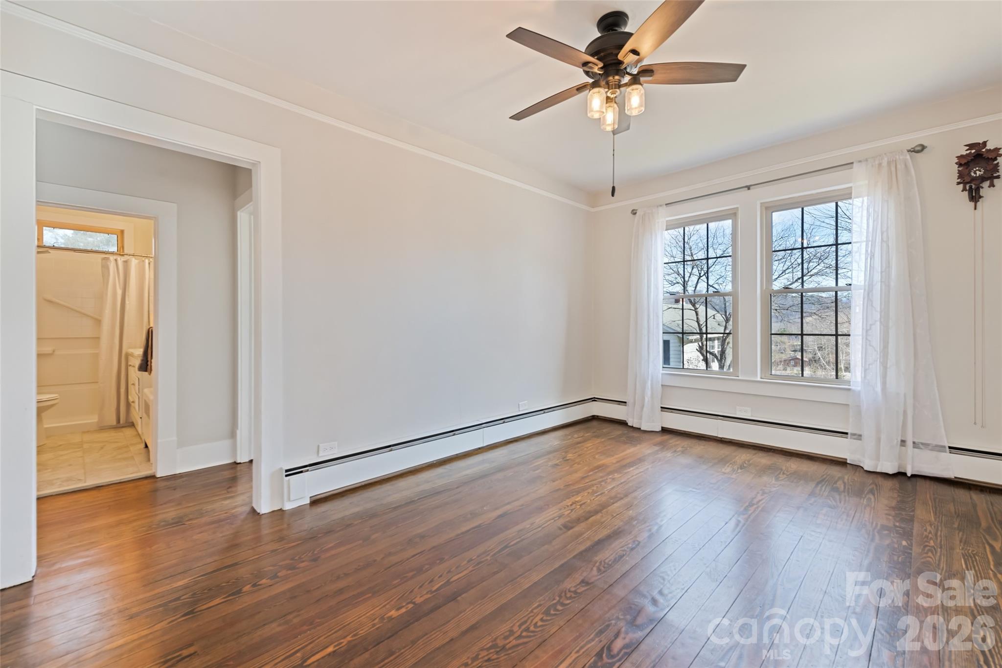 57 Fiddle Drive Canton, NC 28716 - Photo 12 of 35 an empty room with wooden floor chandelier fan and windows