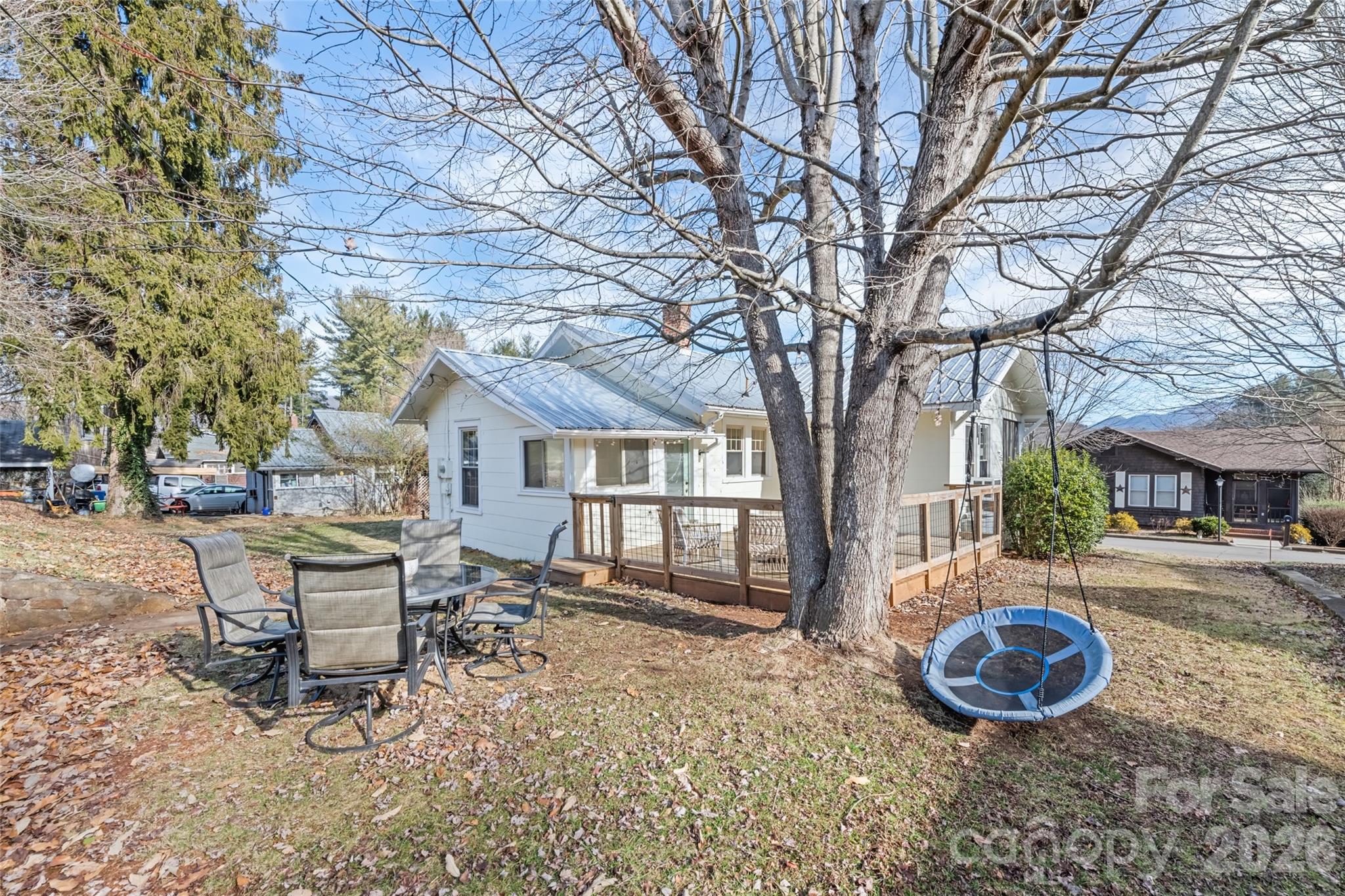 57 Fiddle Drive Canton, NC 28716 - Photo 33 of 35 a table and chairs in front of a white house