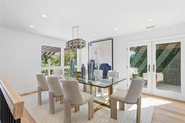 a dining room with furniture a chandelier and wooden floor