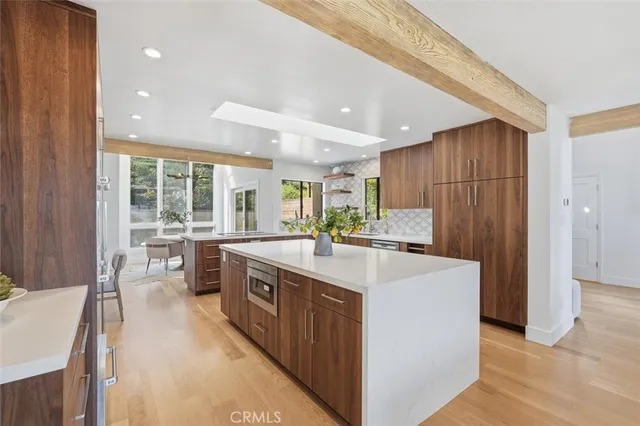 a large kitchen with kitchen island a sink a stove and a refrigerator