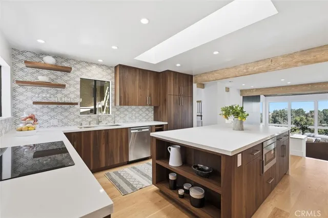 a kitchen with a stove a refrigerator a sink and white cabinets with wooden floor