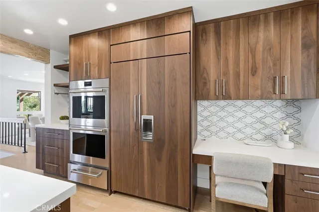 a kitchen with stainless steel appliances a refrigerator and a stove top oven