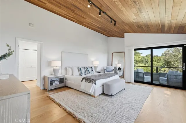 a spacious bedroom with a bed a dresser and cabinets