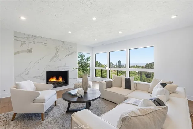 a view of a patio with couches table and chairs with wooden floor and fence