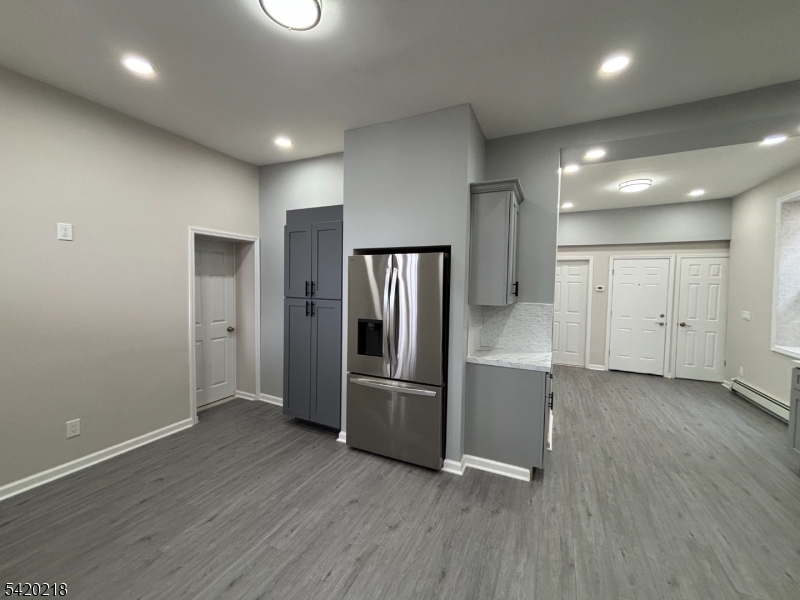 127 Fulton Street Elizabeth Port, NJ 07206 - Photo 11 of 21 an empty room with wooden floor and a refrigerator