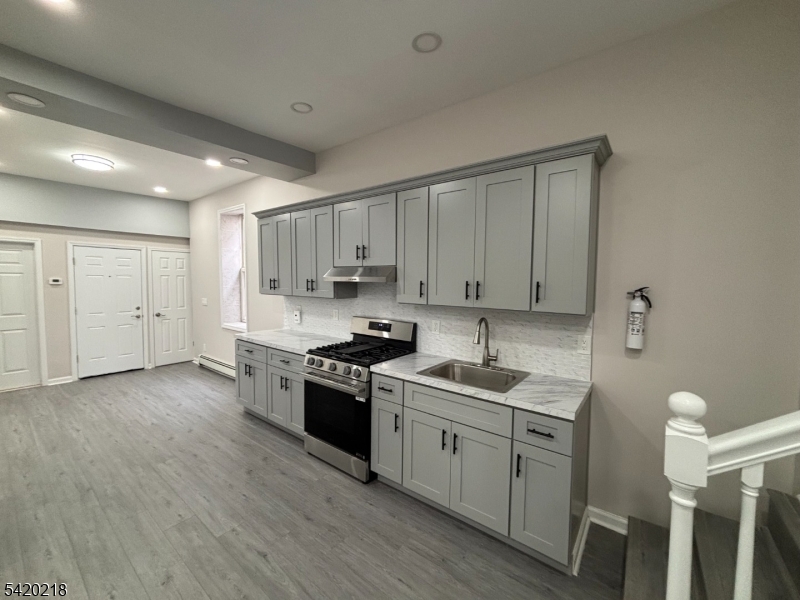 127 Fulton Street Elizabeth Port, NJ 07206 - Photo 9 of 21 a kitchen with cabinets appliances wooden floor and a window