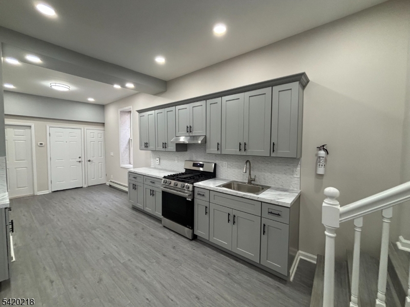127 Fulton Street Elizabeth Port, NJ 07206 - Photo 10 of 21 a kitchen with a sink a stove and cabinets