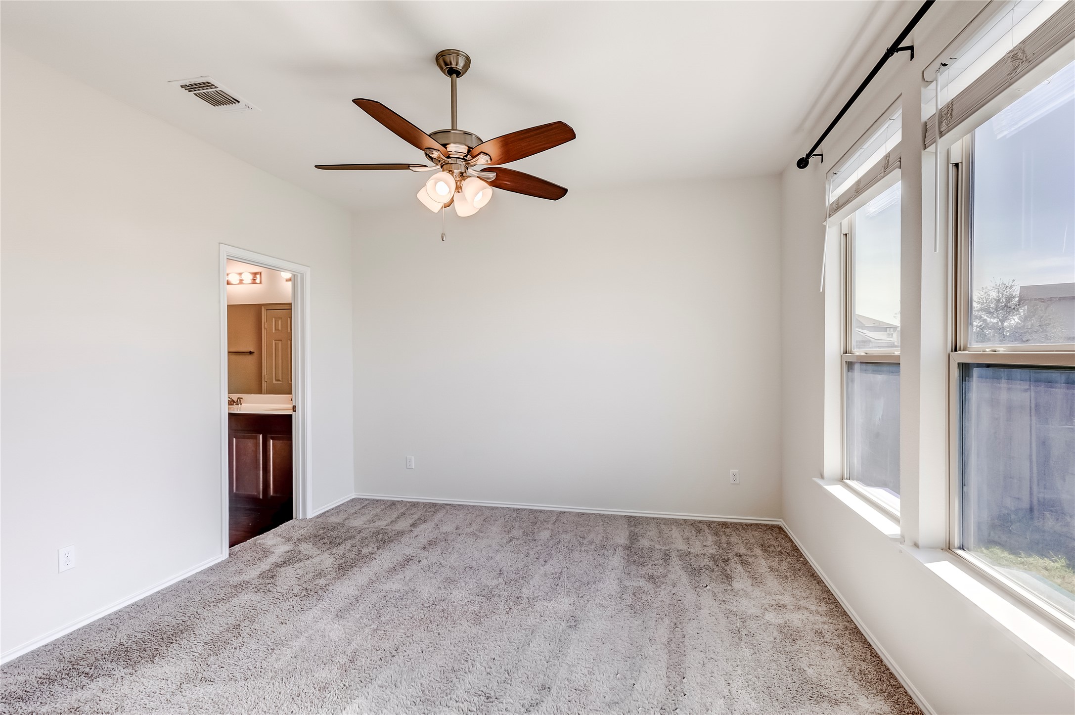 11617 Amber Stream Lane Manor, TX 78653 - Photo 15 of 39 Unfurnished bedroom featuring carpet flooring, a ceiling fan, and ensuite bath