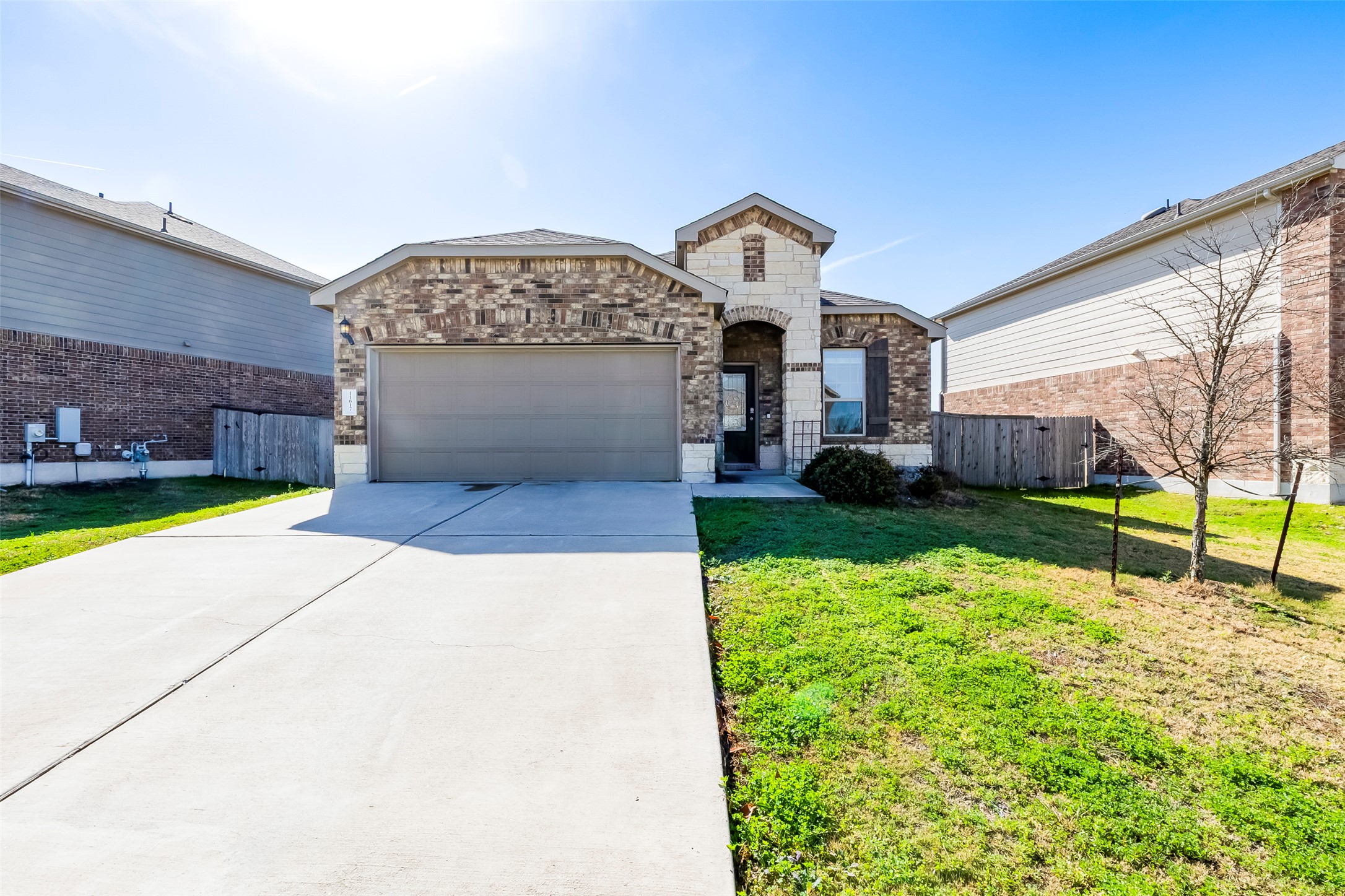 11617 Amber Stream Lane Manor, TX 78653 - Photo 2 of 39 French provincial home featuring brick siding, concrete driveway, an attached garage, and stone siding