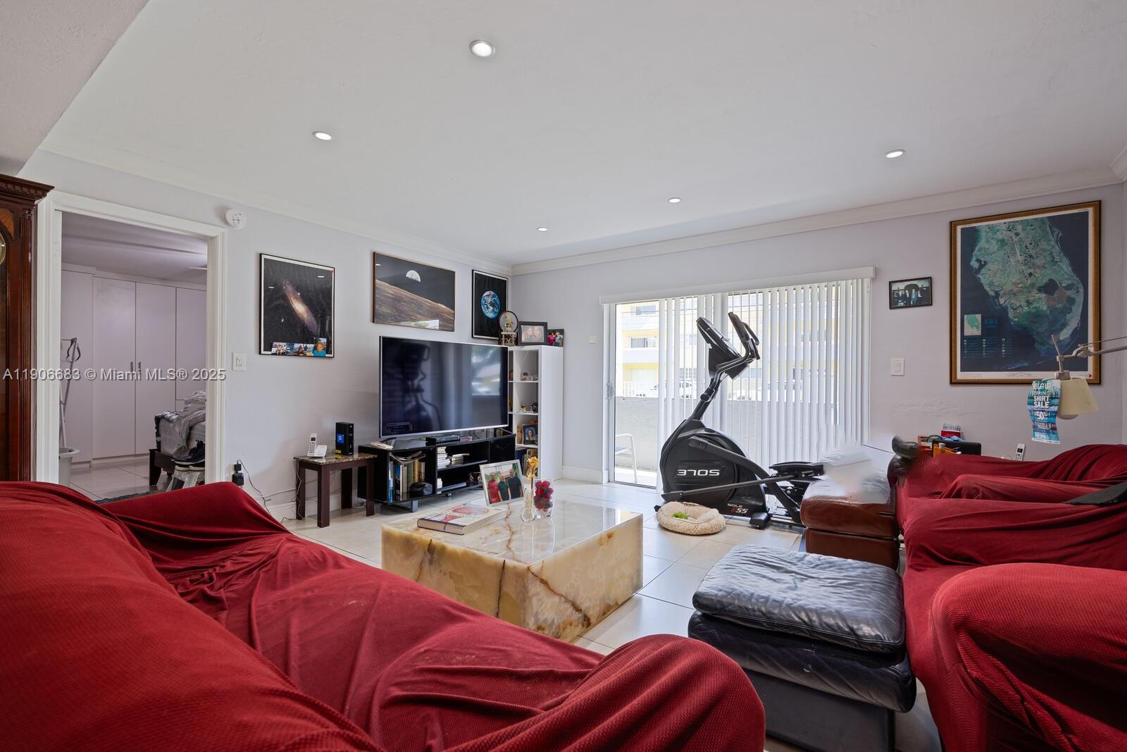 7401 Southwest 82nd Street, Unit 109S Miami, FL 33143 - Photo 2 of 21 a living room with furniture gym equipment and a flat screen tv