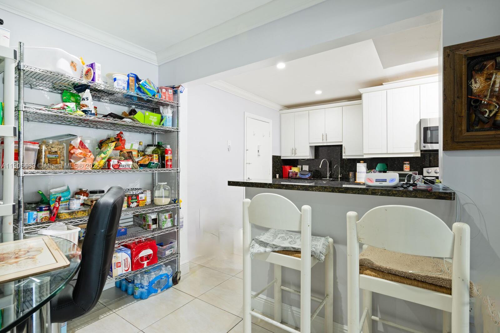 7401 Southwest 82nd Street, Unit 109S Miami, FL 33143 - Photo 6 of 21 a kitchen with granite countertop lots of clutter and stainless steel appliances