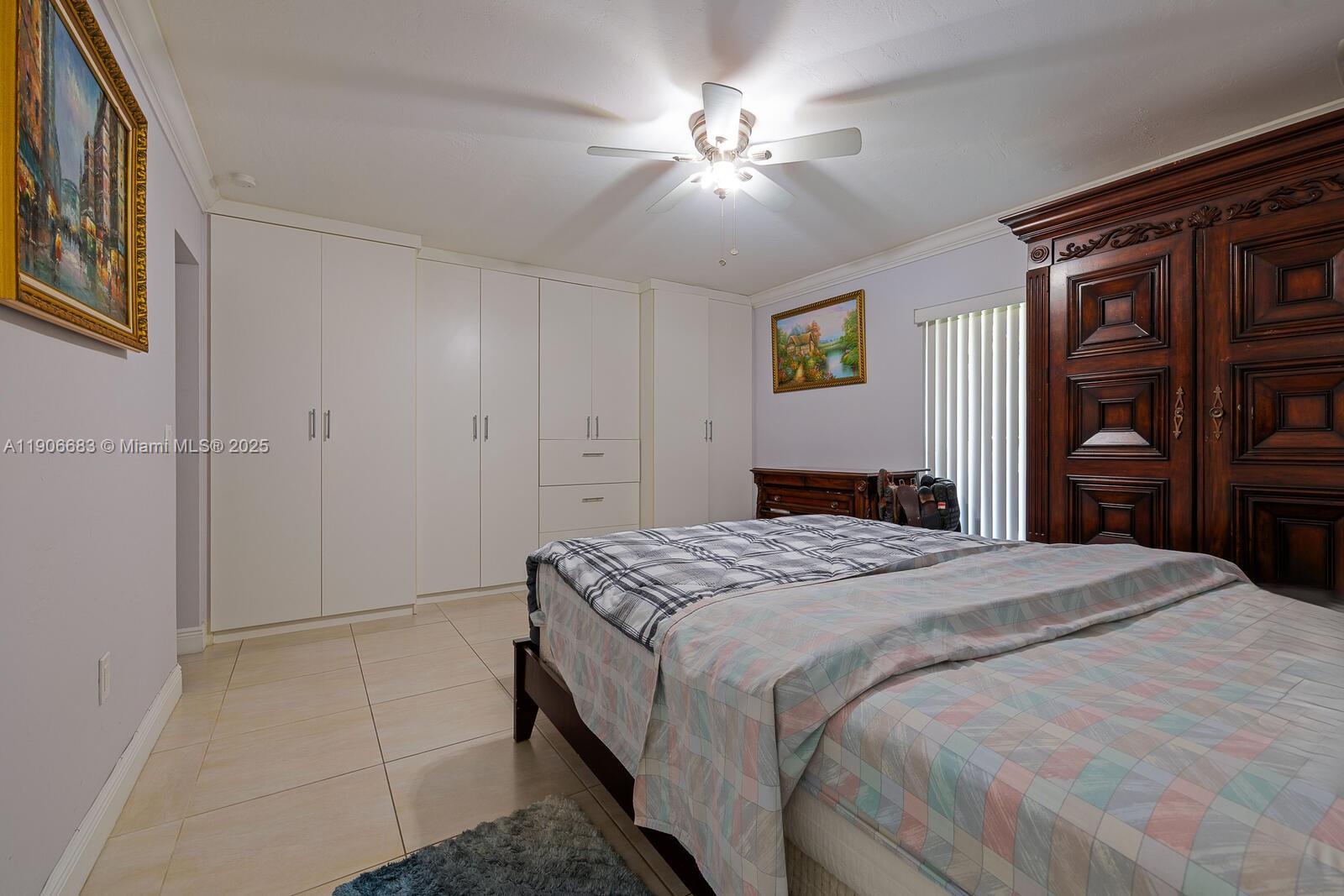7401 Southwest 82nd Street, Unit 109S Miami, FL 33143 - Photo 8 of 21 a bedroom with a bed and a chandelier