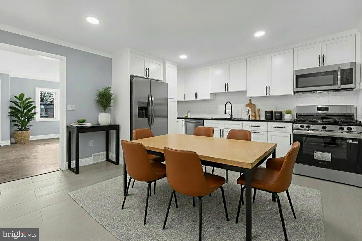 17 Ranchwood Drive Ewing, NJ 08618 - Photo 5 of 33 a kitchen with stainless steel appliances granite countertop a dining table chairs refrigerator and microwave