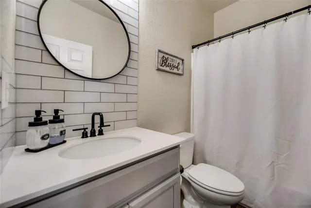 a bathroom with a sink a toilet and a mirror