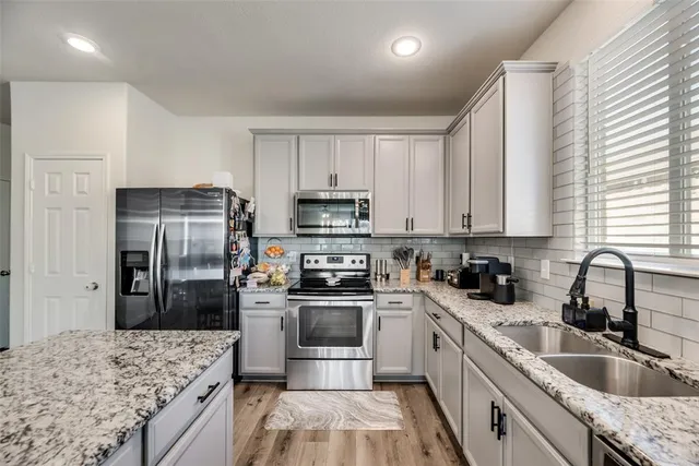 a kitchen with a sink stove and refrigerator