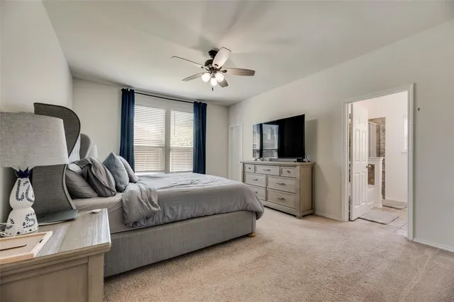 a spacious bedroom with a bed and a flat screen tv