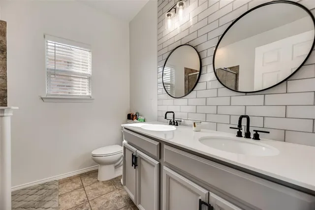 a bathroom with a sink a toilet and a mirror