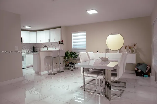 a living room with a sink dining table and chairs