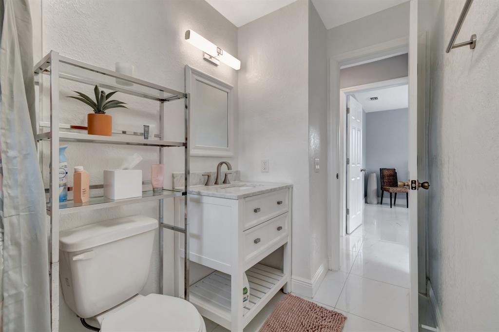 710 Southeast 3rd Avenue Delray Beach, FL 33483 - Photo 18 of 31 a bathroom with a toilet sink vanity and mirror