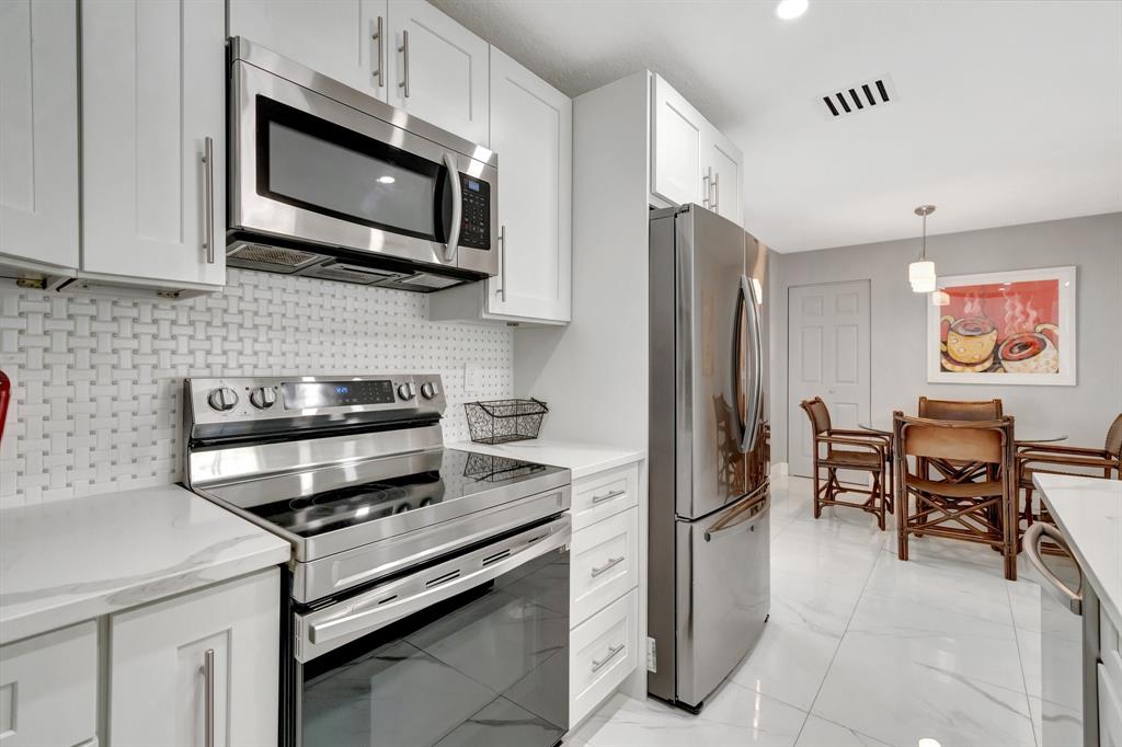 710 Southeast 3rd Avenue Delray Beach, FL 33483 - Photo 7 of 31 a kitchen with stainless steel appliances granite countertop a refrigerator microwave and sink