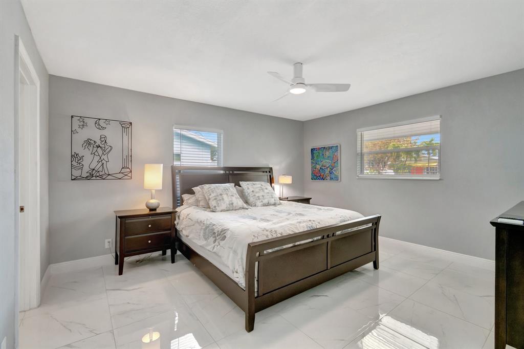 710 Southeast 3rd Avenue Delray Beach, FL 33483 - Photo 8 of 31 a bedroom with a bed and a lamp on dresser