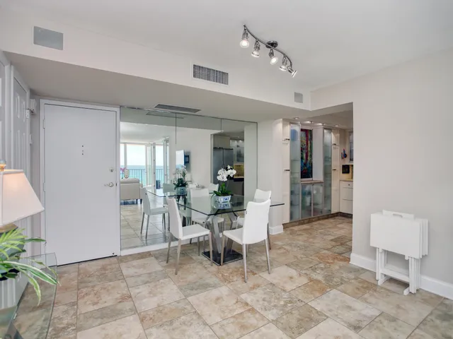 a living room with furniture a dining table and a chandelier