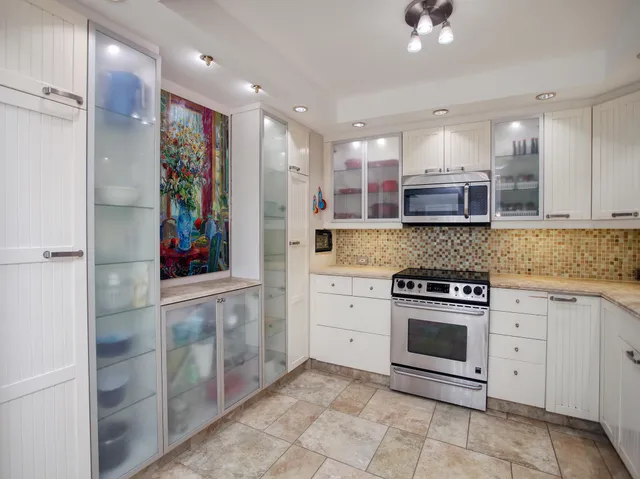 a kitchen with stainless steel appliances granite countertop a refrigerator and a stove top oven