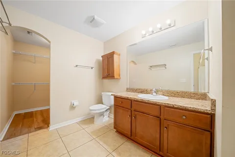 a bathroom with a granite countertop sink a toilet and a mirror