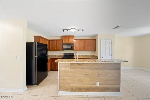 a kitchen with stainless steel appliances granite countertop a refrigerator and a stove