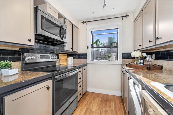 a kitchen with stainless steel appliances granite countertop a stove a sink and a microwave