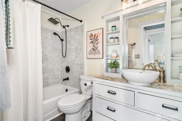 a bathroom with a granite countertop sink a toilet and a bathtub