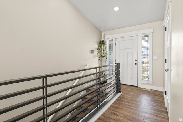 463 South Trejo Ridge Road Grantsville, UT 84029 - Photo 2 of 22 Entryway featuring wood-finish flooring, a contemporary metal railing, a white paneled entry door with sidelights, and recessed lighting