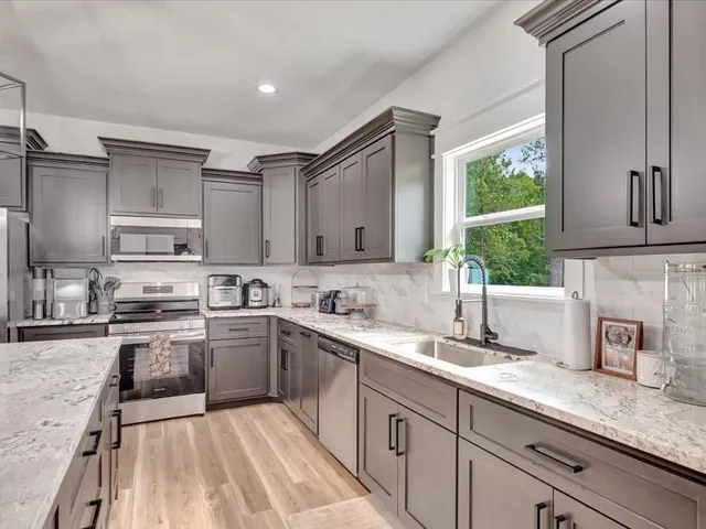 a kitchen with stainless steel appliances granite countertop a sink stove and cabinets