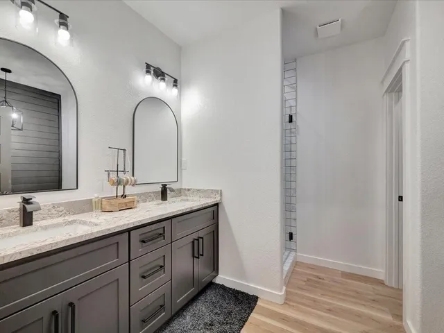 a bathroom with a double vanity sink and a mirror