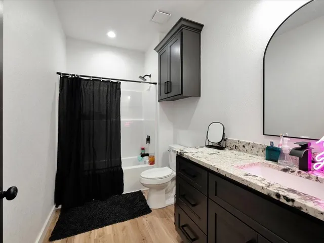 a bathroom with a granite countertop sink toilet and shower
