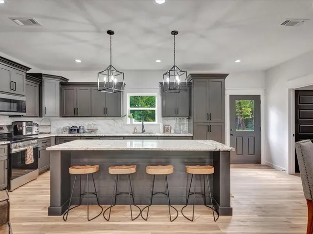a large kitchen with granite countertop a counter space and stainless steel appliances