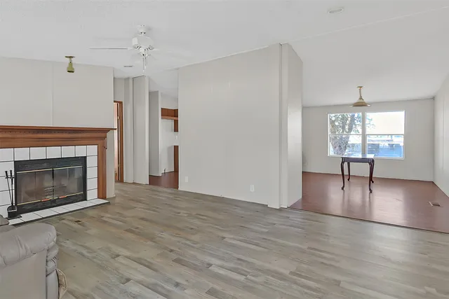 a view of empty room with fireplace and wooden floor
