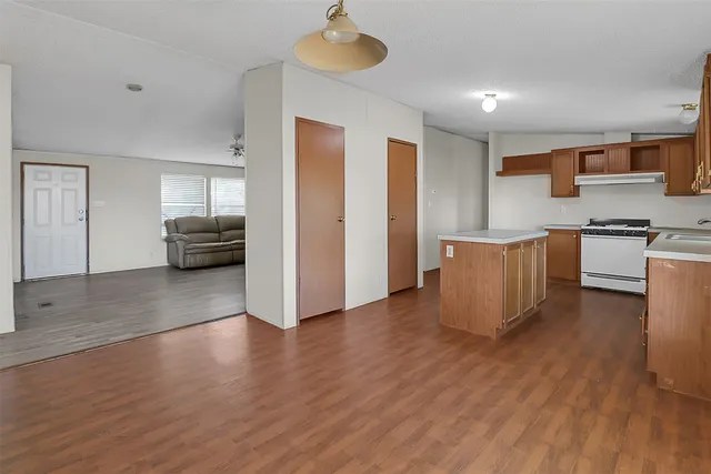 a view of a kitchen with furniture and wooden floor