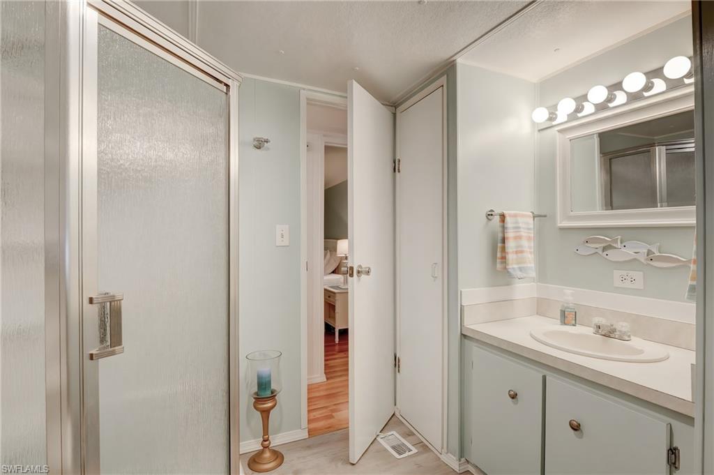 104 Willow Lane, Unit 30 Naples, FL 34114 - Photo 13 of 27 a bathroom with a shower sink and mirror