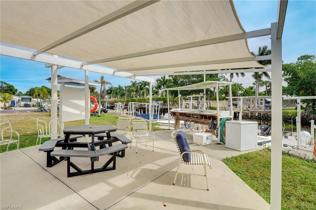 104 Willow Lane, Unit 30 Naples, FL 34114 - Photo 23 of 27 a building outdoor space with patio furniture and potted plants