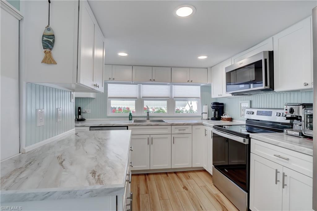 104 Willow Lane, Unit 30 Naples, FL 34114 - Photo 5 of 27 a kitchen with stainless steel appliances granite countertop a sink stove and refrigerator