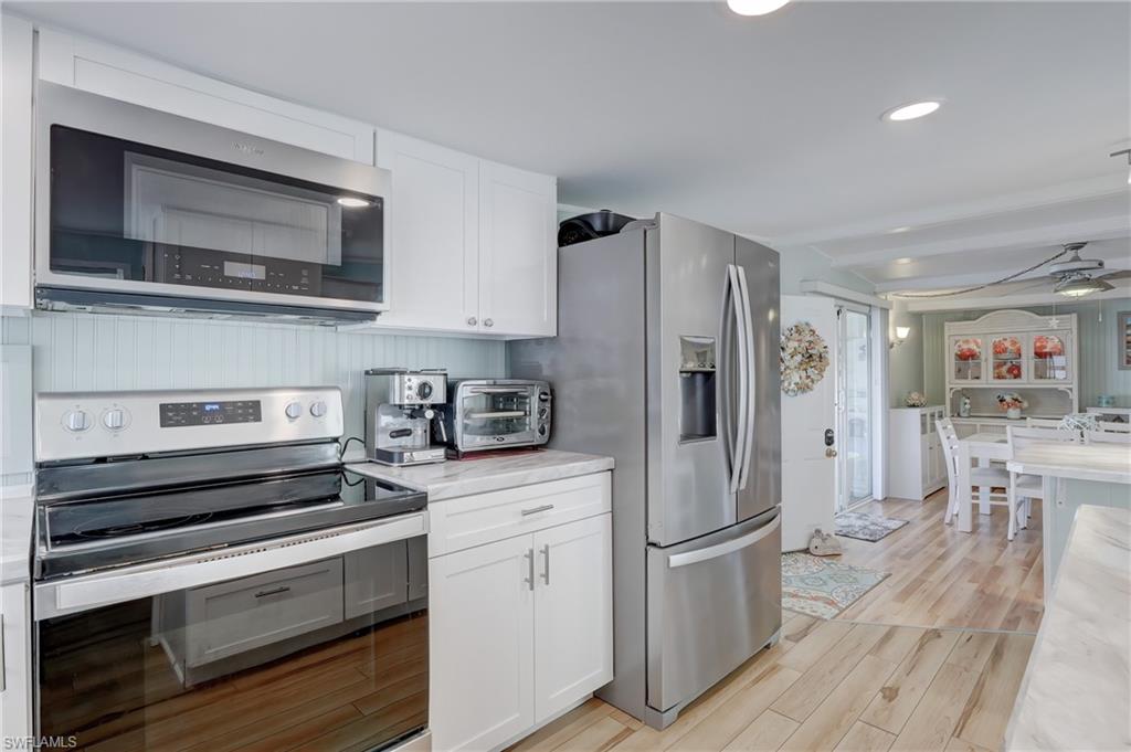 104 Willow Lane, Unit 30 Naples, FL 34114 - Photo 6 of 27 a kitchen with stainless steel appliances a refrigerator stove and microwave