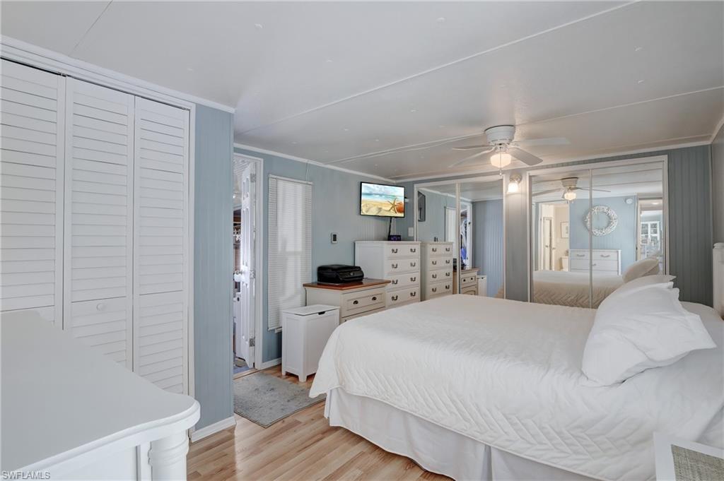 104 Willow Lane, Unit 30 Naples, FL 34114 - Photo 8 of 27 a spacious bedroom with a bed and a chandelier